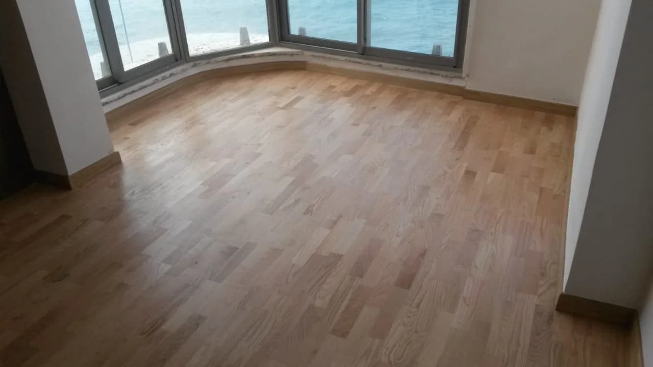 Parquet clair posé en lames droites devant de grandes baies vitrées